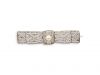 Broche des années 1925 en platine, en forme de noeud, ornée de diamants taille 8/8 en serti millegrain et d'une perle